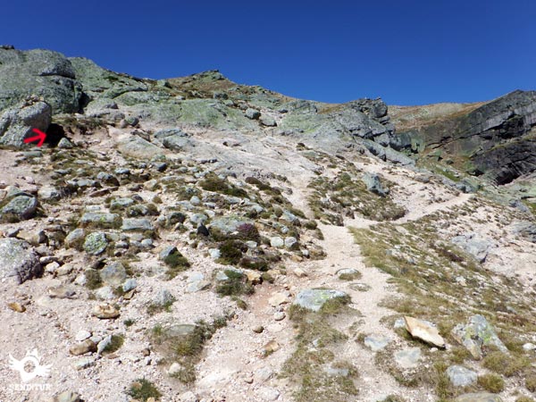 El hito de piedras sobre la roca marca la senda que discurre unos pocos metros más arriba de la otra